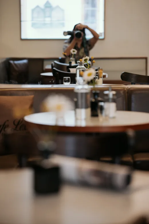 Blick in den Gastraum des Café Lex mit gedeckten Tischen und Blumen